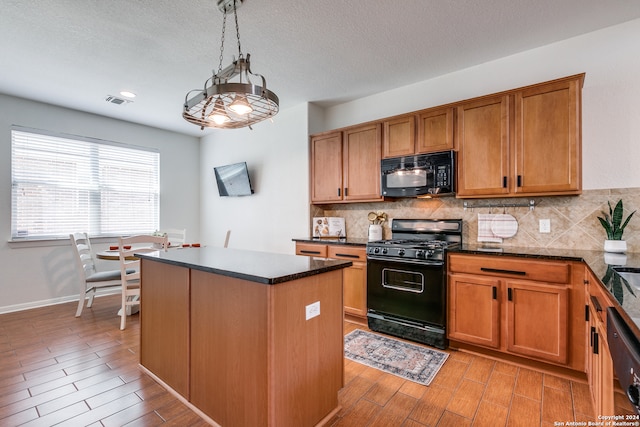 kitchen featuring pendant lighting, dark stone counters, a chandelier, backsplash, and black appliances