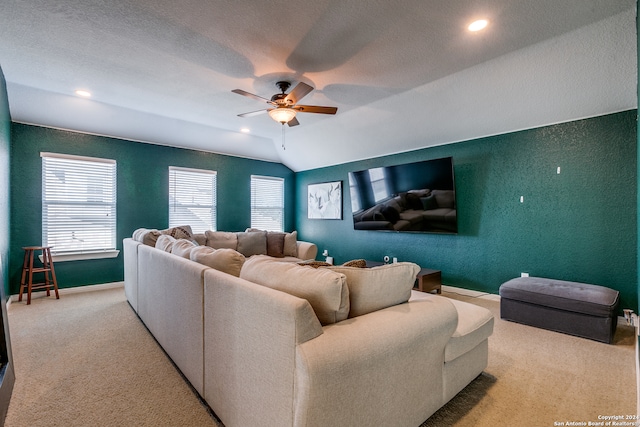 living room featuring light carpet, vaulted ceiling, a textured ceiling, and ceiling fan