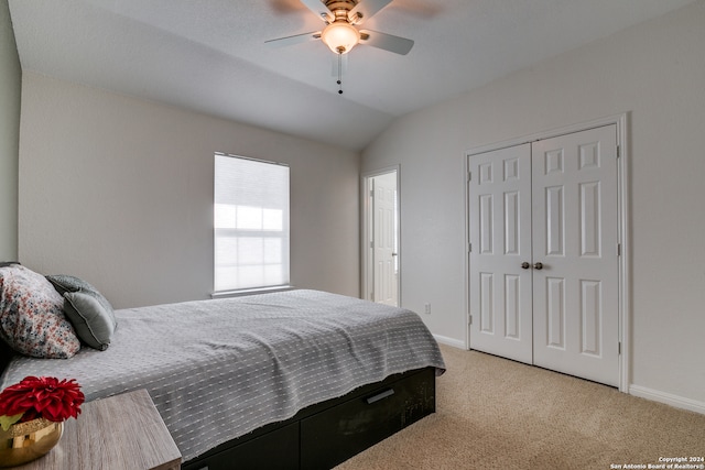 carpeted bedroom featuring a closet, lofted ceiling, and ceiling fan