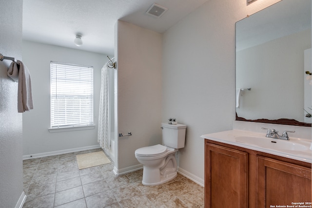 bathroom with toilet, vanity, and tile flooring