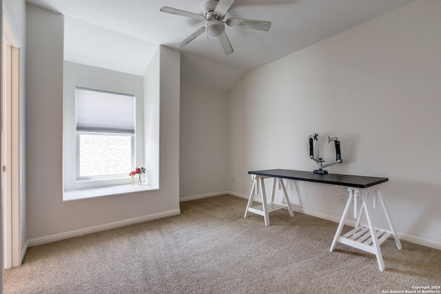 unfurnished office featuring vaulted ceiling, light colored carpet, and ceiling fan