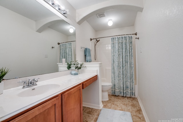 bathroom featuring tile flooring, vanity with extensive cabinet space, and toilet