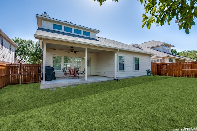 rear view of property with ceiling fan, a lawn, and a patio