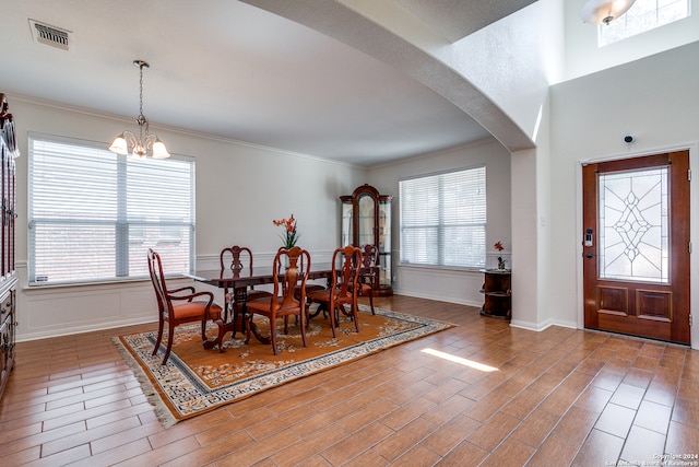 dining area featuring plenty of natural light, an inviting chandelier, and dark hardwood / wood-style flooring