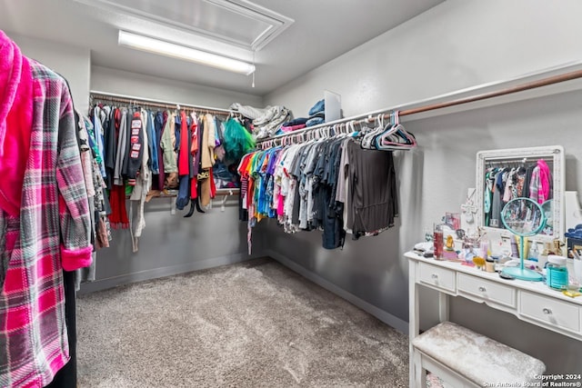 walk in closet featuring dark carpet