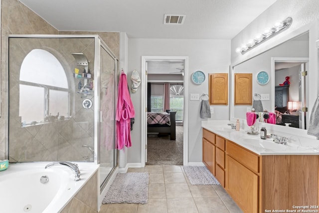 bathroom featuring tile flooring, double sink, a textured ceiling, vanity with extensive cabinet space, and separate shower and tub