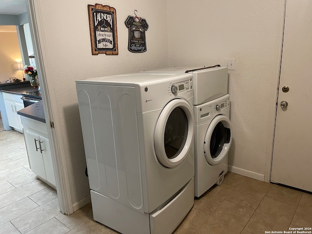 clothes washing area with light tile floors and washing machine and dryer