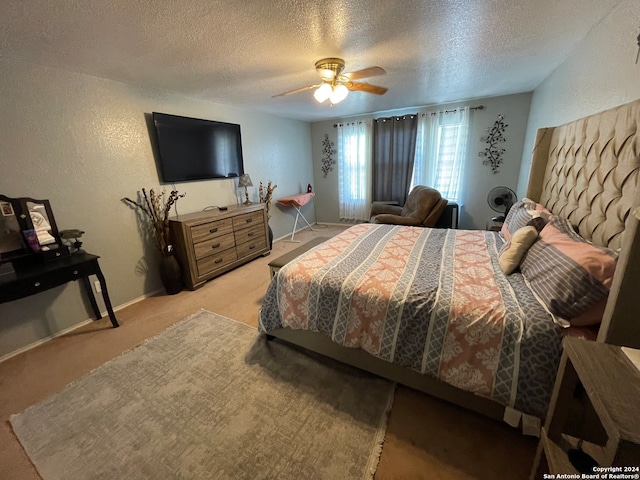 carpeted bedroom with ceiling fan and a textured ceiling