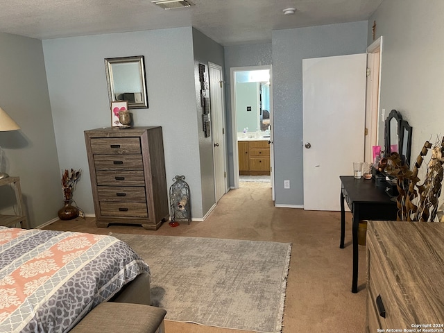 carpeted bedroom with ensuite bathroom and sink