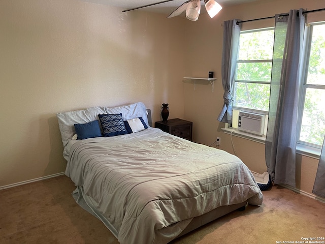 carpeted bedroom featuring ceiling fan and multiple windows