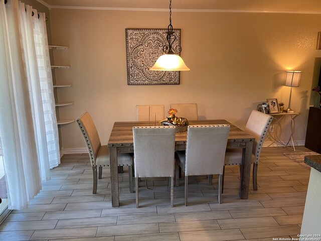 dining area with light hardwood / wood-style floors and ornamental molding