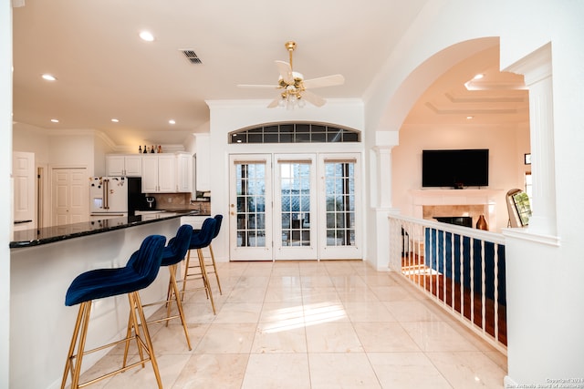 kitchen featuring white refrigerator, tasteful backsplash, white cabinetry, and a healthy amount of sunlight