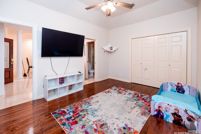 interior space featuring light tile flooring, ceiling fan, decorative columns, and a closet