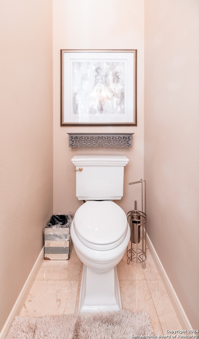 bathroom with toilet and tile floors