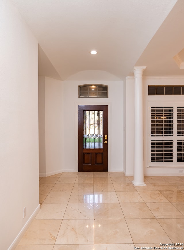 foyer entrance featuring light tile floors and ornate columns