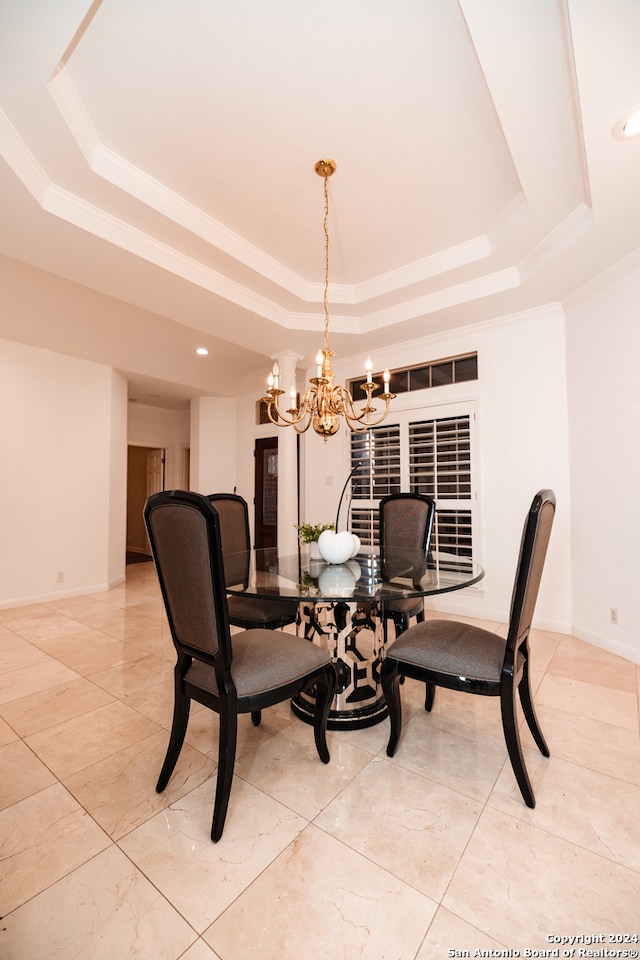 tiled dining area featuring an inviting chandelier and a tray ceiling