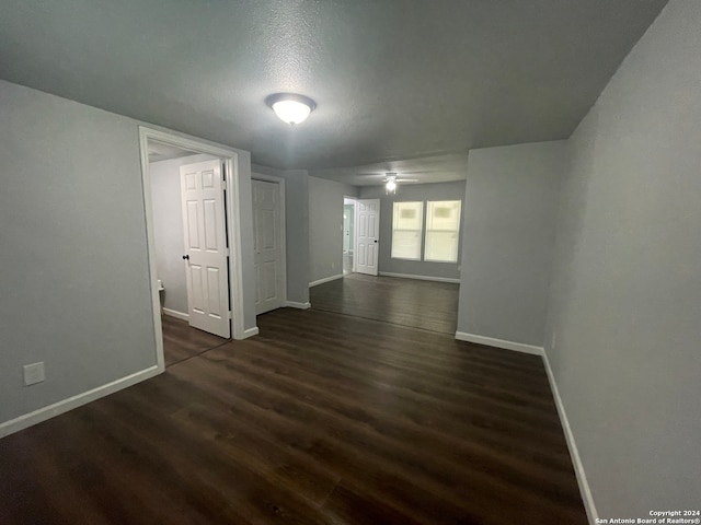 empty room featuring dark hardwood / wood-style flooring, ceiling fan, and a textured ceiling