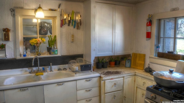 kitchen featuring stainless steel range oven, light countertops, and a sink