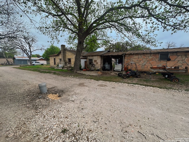 view of front facade featuring dirt driveway and stone siding