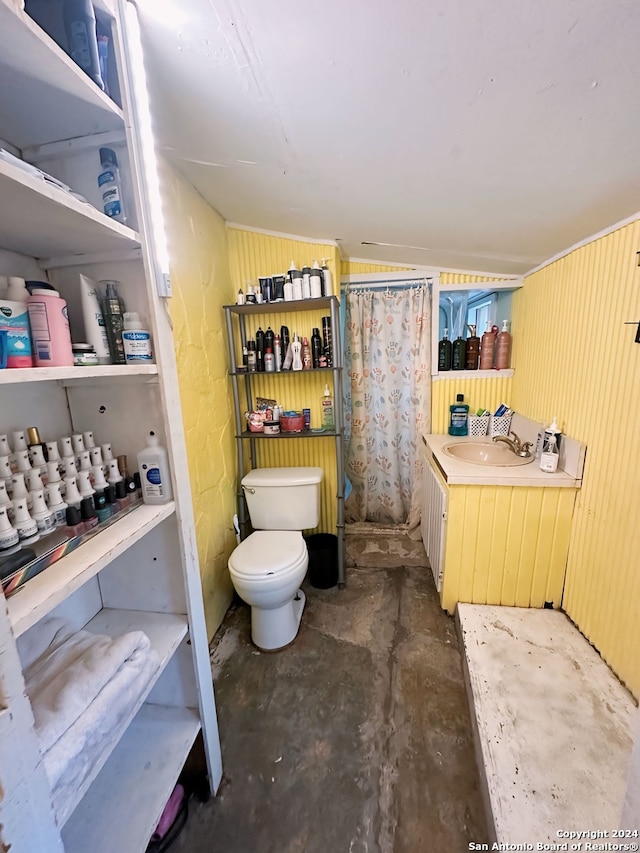 bathroom featuring concrete flooring, curtained shower, a sink, and toilet