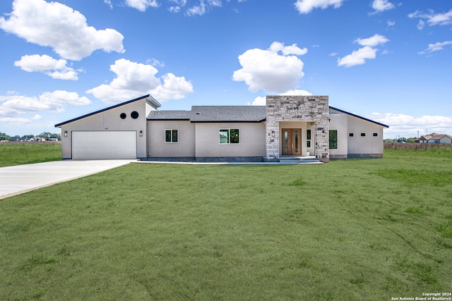 view of front of house featuring french doors, a front yard, and a garage