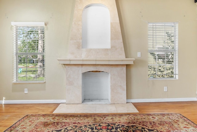 living room featuring light hardwood / wood-style floors, a healthy amount of sunlight, and a tiled fireplace