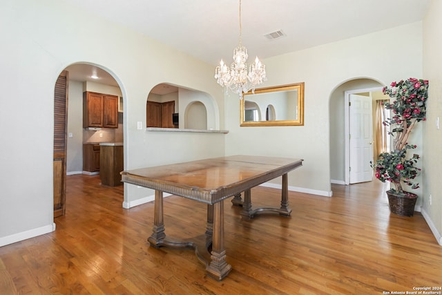 dining space featuring dark hardwood / wood-style floors and a chandelier