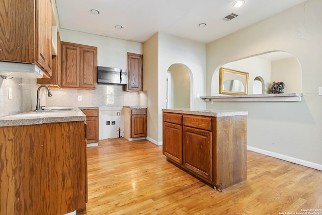 kitchen featuring light hardwood / wood-style flooring, sink, and backsplash