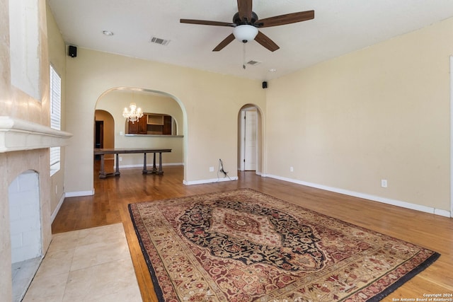 interior space with light hardwood / wood-style floors and ceiling fan with notable chandelier