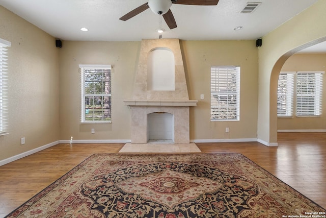 living room featuring a fireplace, light hardwood / wood-style floors, and ceiling fan