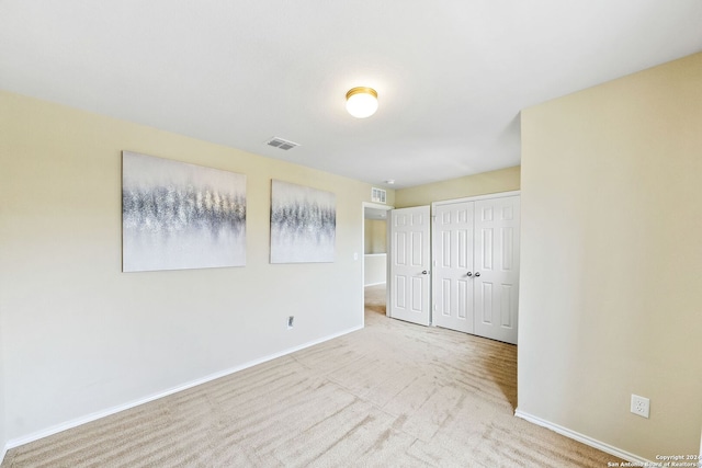 unfurnished room featuring light carpet