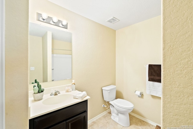 bathroom with toilet, vanity, and tile flooring