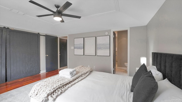 bedroom featuring ensuite bathroom, ceiling fan, and hardwood / wood-style flooring