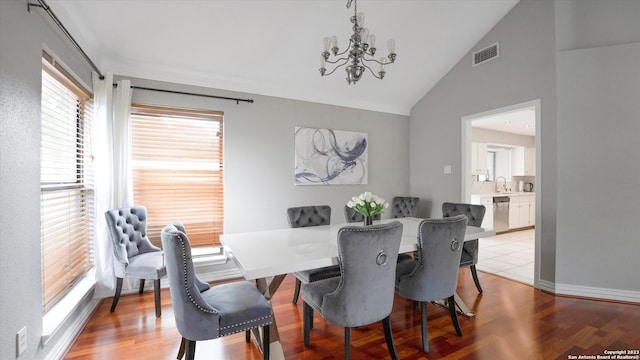 dining area featuring plenty of natural light, light hardwood / wood-style flooring, a chandelier, and lofted ceiling