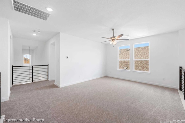 empty room featuring ceiling fan and carpet