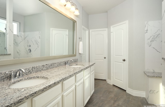 bathroom with tile floors, vanity with extensive cabinet space, and double sink