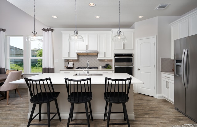 kitchen featuring tasteful backsplash, dark wood-type flooring, appliances with stainless steel finishes, and white cabinetry