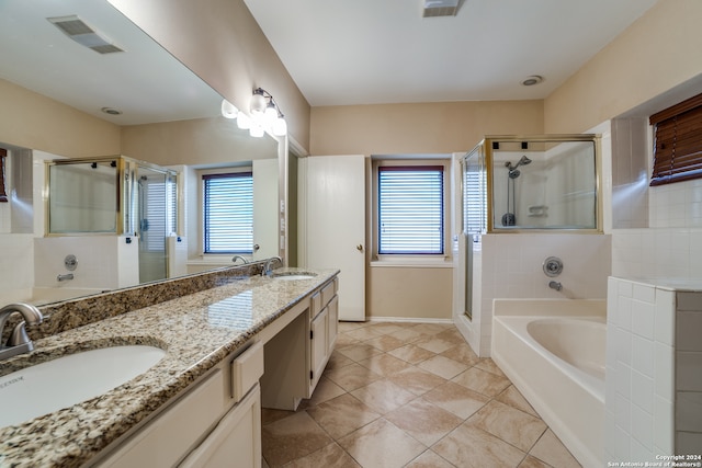 bathroom with a wealth of natural light, vanity with extensive cabinet space, double sink, and tile flooring