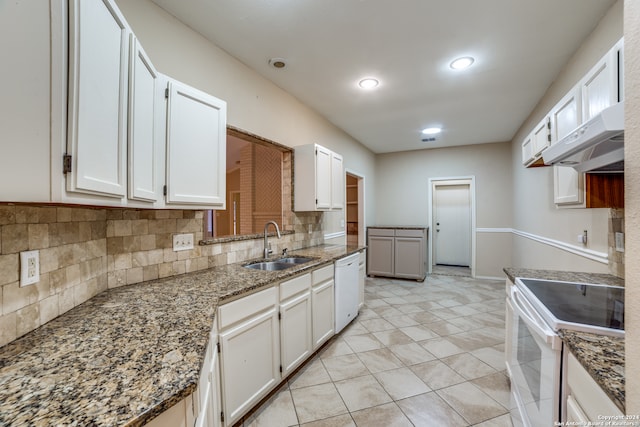 kitchen with white appliances, white cabinetry, sink, tasteful backsplash, and dark stone countertops