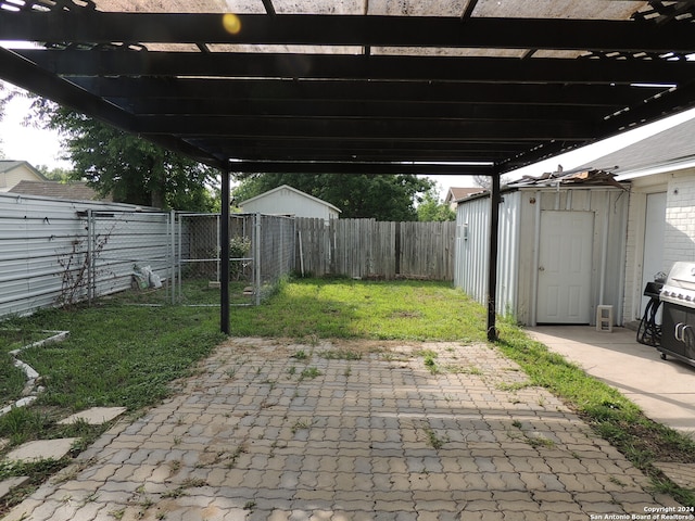 view of patio / terrace with area for grilling, a storage unit, and a pergola