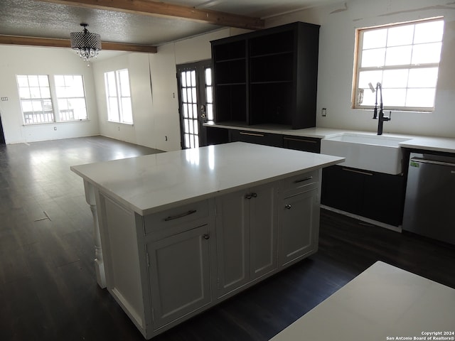 kitchen with stainless steel dishwasher, dark hardwood / wood-style flooring, a kitchen island, and beam ceiling