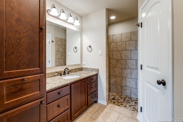 bathroom featuring walk in shower, tile flooring, and vanity