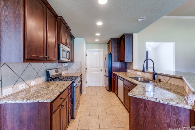 kitchen with light tile floors, tasteful backsplash, appliances with stainless steel finishes, light stone counters, and sink