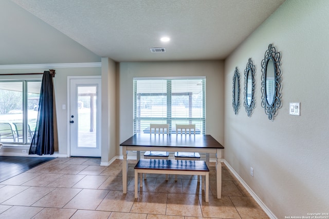 tiled dining area featuring a textured ceiling