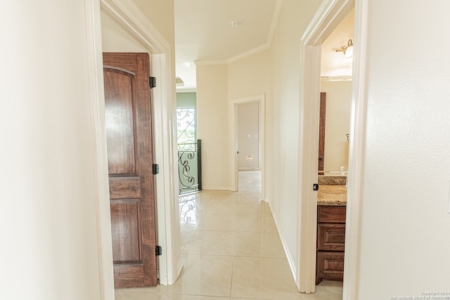 hallway featuring ornamental molding and light tile flooring