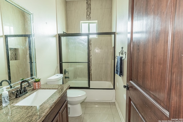 full bathroom with vanity, combined bath / shower with glass door, tile flooring, and toilet