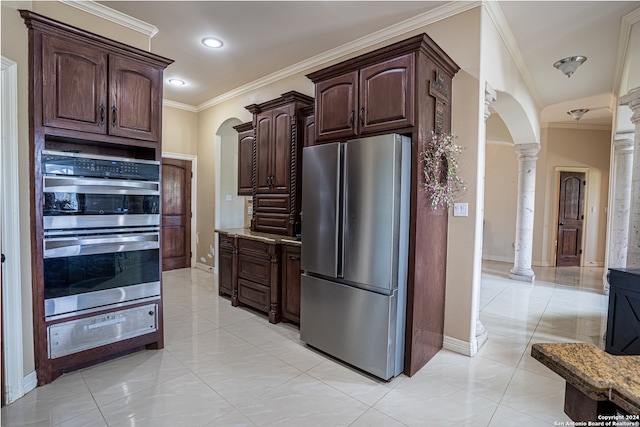 kitchen with appliances with stainless steel finishes, light stone counters, ornate columns, and light tile flooring