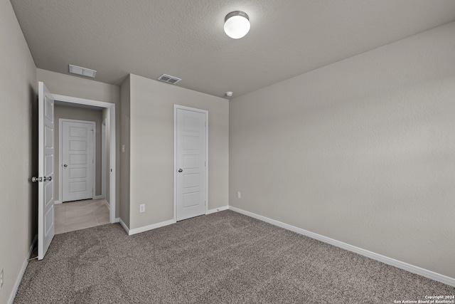 unfurnished bedroom with carpet flooring and a textured ceiling