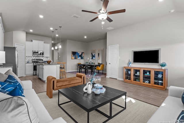 living room featuring ceiling fan and lofted ceiling