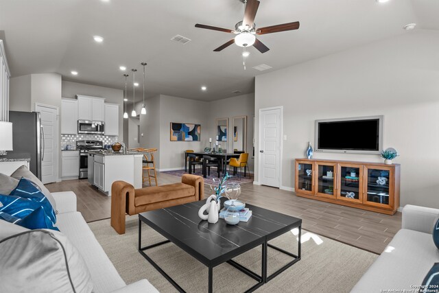 living room with lofted ceiling and ceiling fan